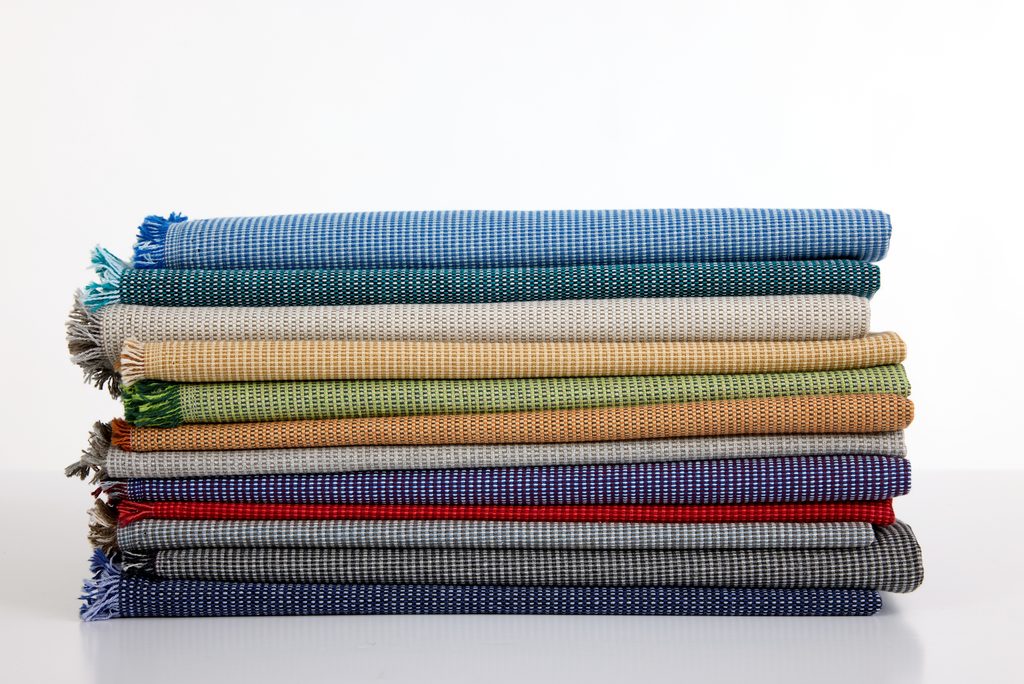 Luum Hive upholstery fabric swatches stacked in blue, green, yellow, gray, red, and neutral colors
