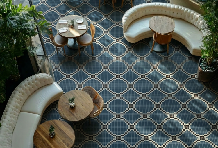 Artaic Marais mosaic tile flooring in Cobalt, with a blue geometric lattice pattern across a restaurant floor with curved banquettes and wood tables.