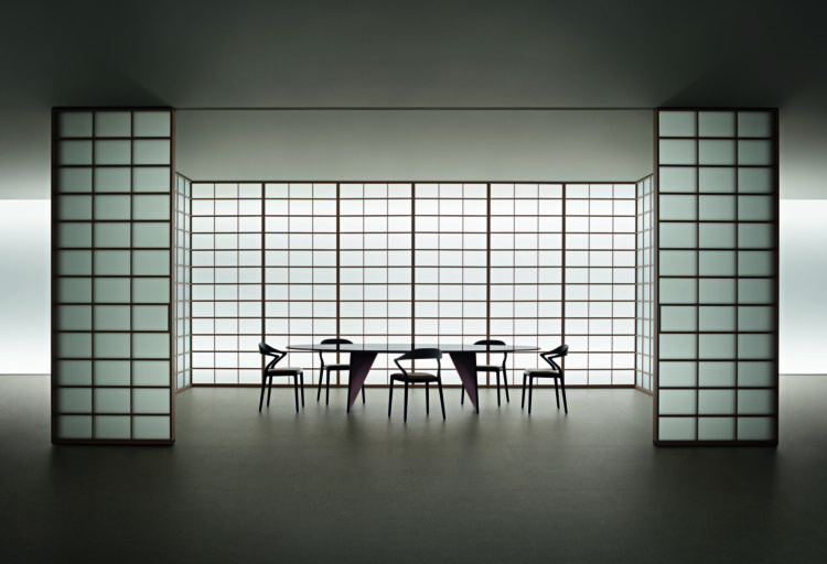Rimadesio Syncro sliding panel system with translucent grid panels open around a dining area.