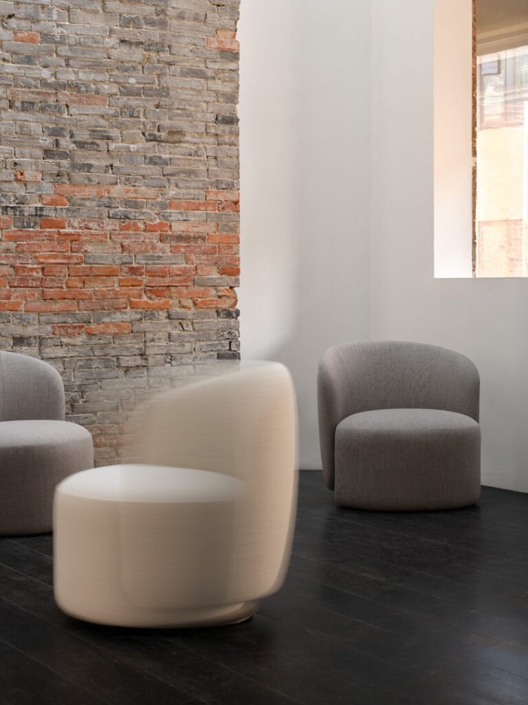 Stellar Works Taylor One-Seater chairs in gray upholstery against an exposed brick wall.