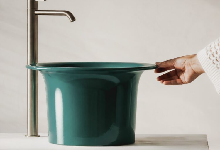Green Valdama Sciapó vessel sink on a stone counter with a brushed metal faucet.