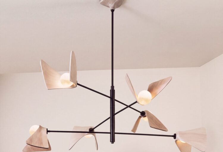 Cyclamen three-tier chandelier with six glowing globes nestled in cerused wood petals on branching dark metal arms.