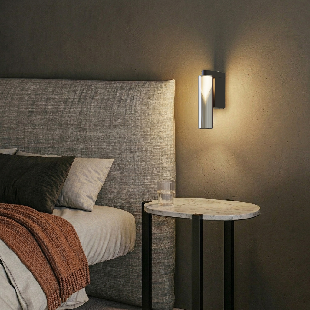 Penta Iconica glass wall sconce casting warm light above a marble bedside table beside an upholstered headboard.