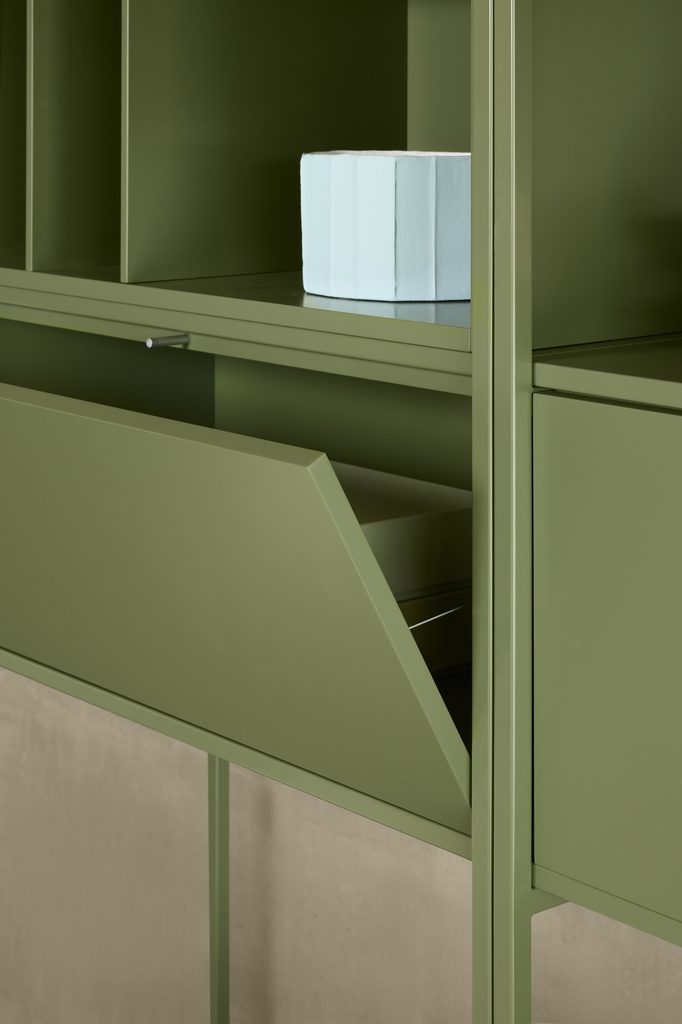 Close-up of green Line System shelving with divided cubbies and a partially open drop-down cabinet door.