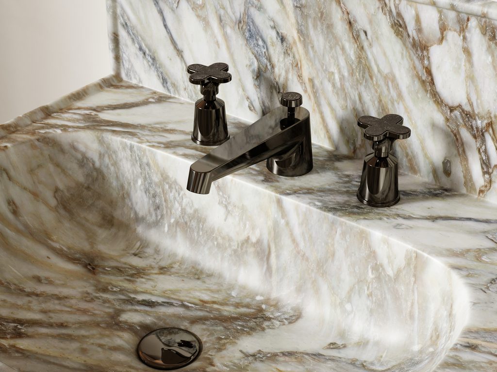 Watermark Dualis marble faucet handles in a clover shape with dark metal fittings on a veined stone sink.